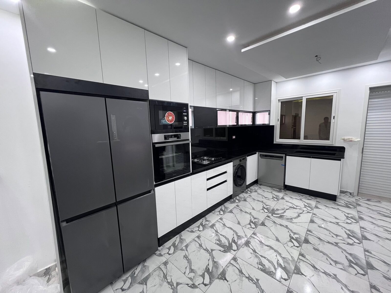 Cuisine blanche et noire sur sol en marbre — Moderne · Tanger