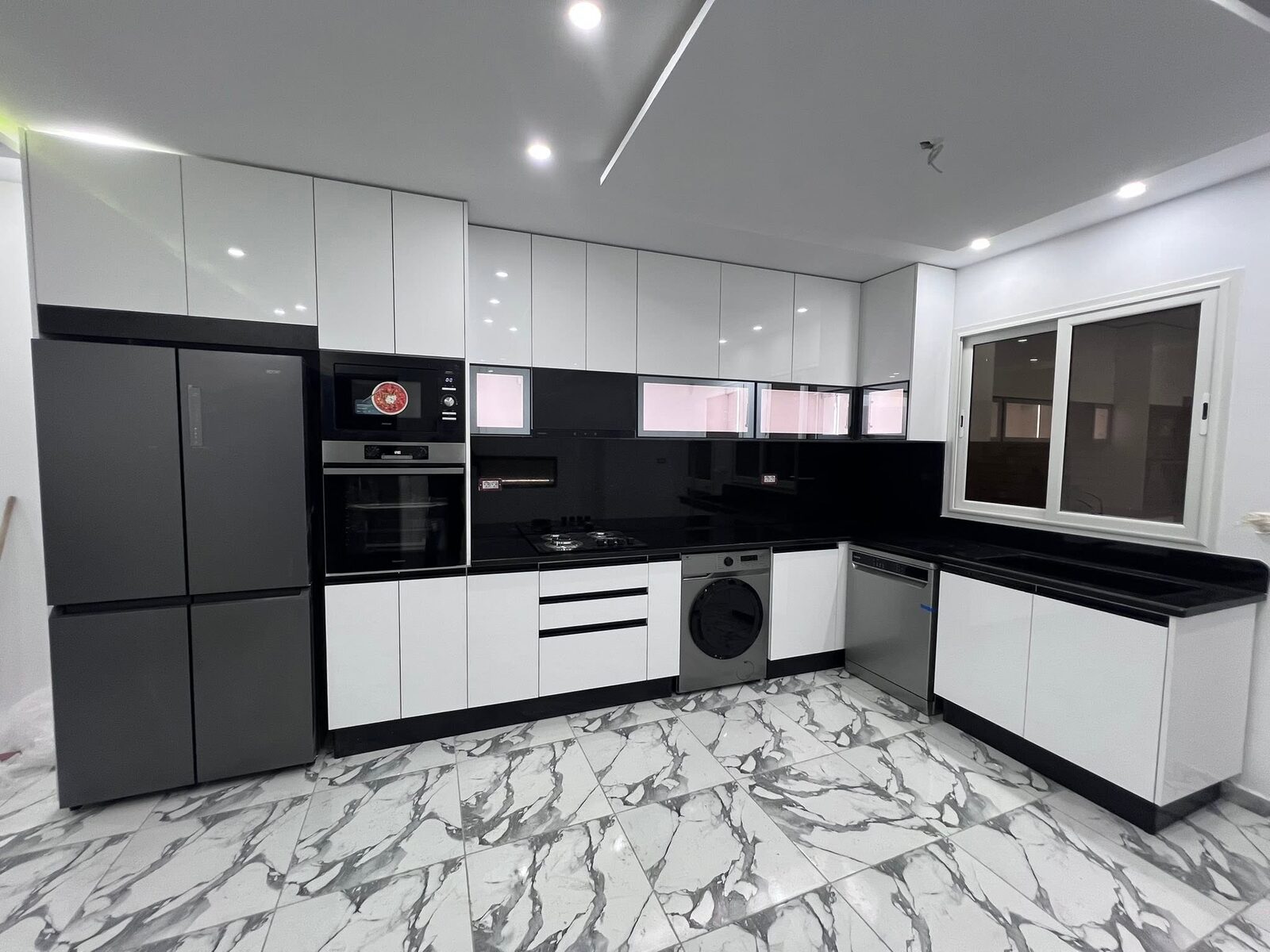 Cuisine équipée blanche et noire avec électroménager intégré — réalisation à Tanger