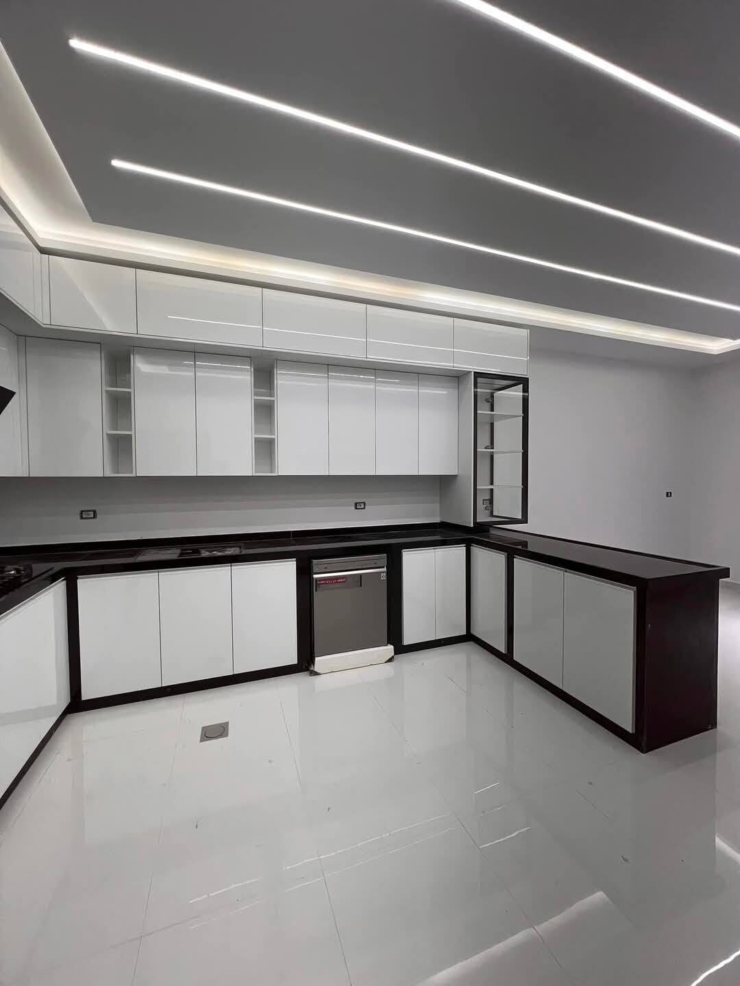 Cuisine équipée blanche et noire en L, lumineuse — agencement sur mesure à Tanger