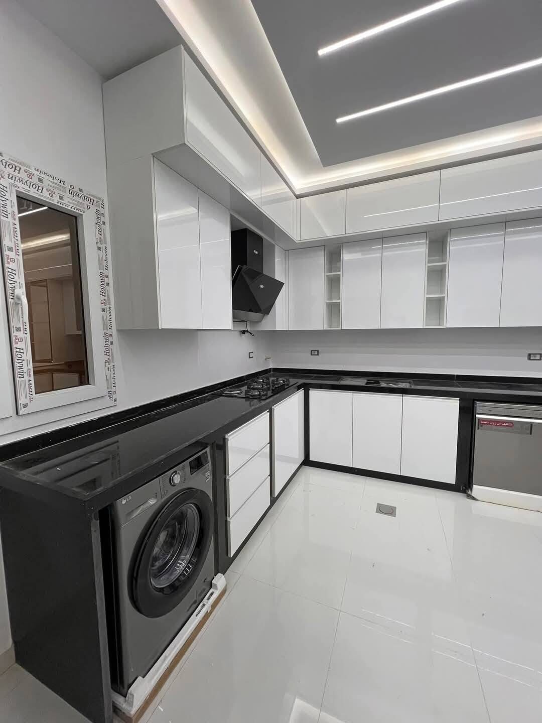 Cuisine en L blanche et noire avec électroménager — réalisation Crafted & Kitchens à Tanger